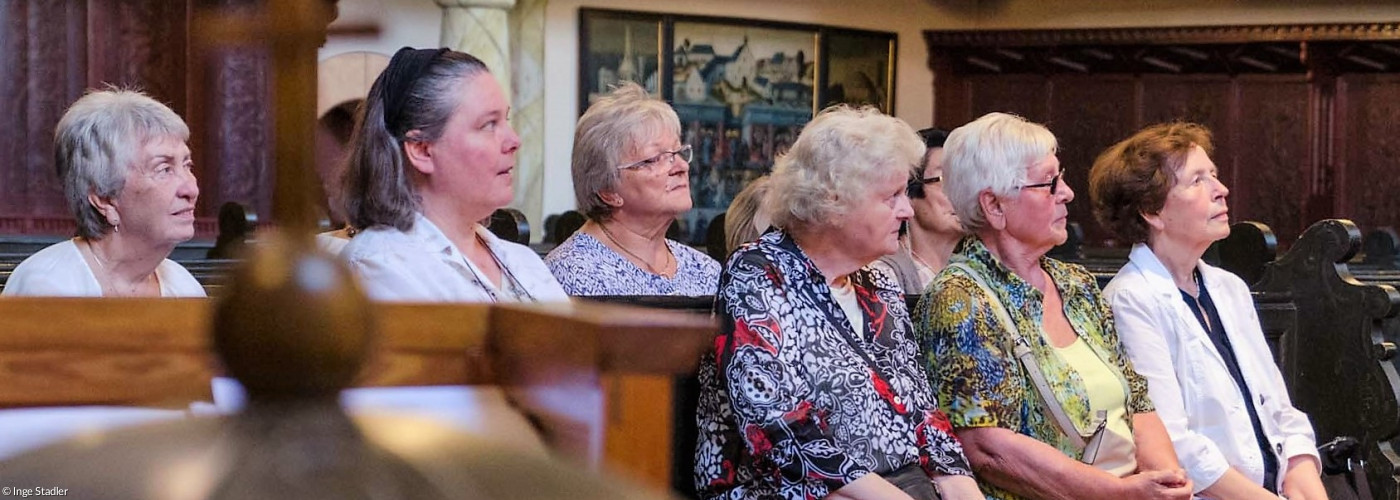 Zu sehen sind Teilnehmer des Frauenkreises auf einer Kirchenbank